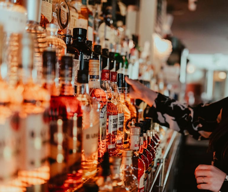 Abbildung einer Bar, in der viele verschiedene Flaschen stehen